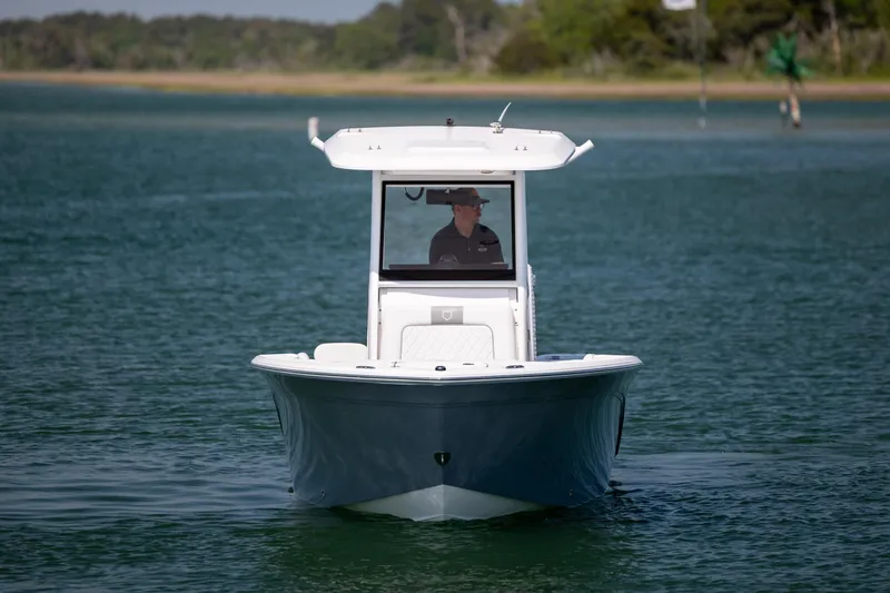 Slide: The Image of 2025 Sea Fox 228 Commander boat cruising on calm water with a person at the helm. - 3