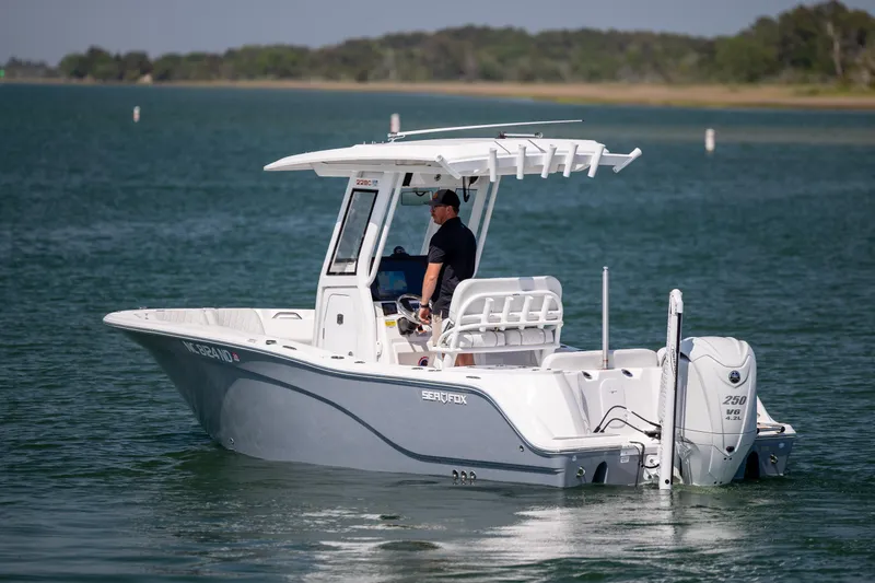 Slide: The Image of 2025 Sea Fox 228 Commander boat cruising on a calm lake with a captain onboard. - 6