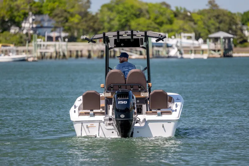 Slide: The Image of 2025 Sea Pro 202 Center Console boat cruising on a calm lake with a scenic backdrop. - 11