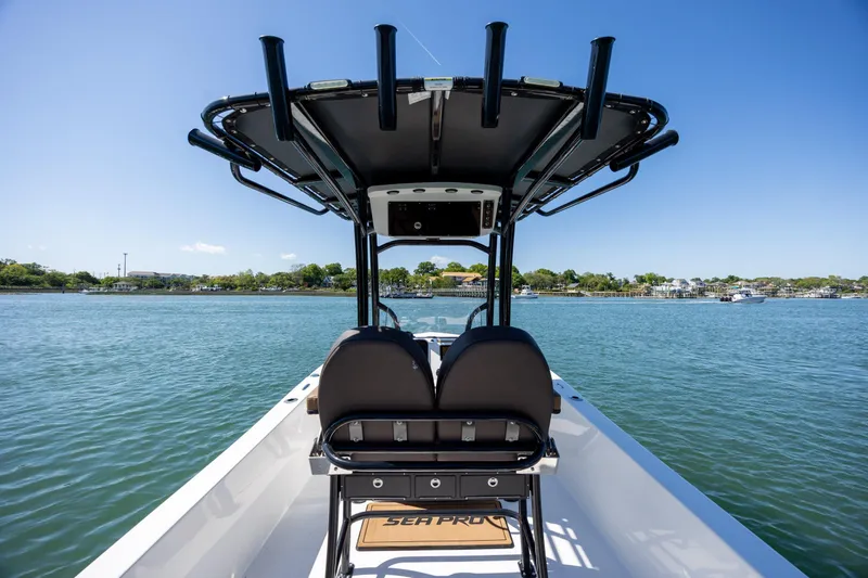 Slide: The Image of 2025 Sea Pro 202 Center Console boat on calm water, featuring sleek design and spacious seating. - 14