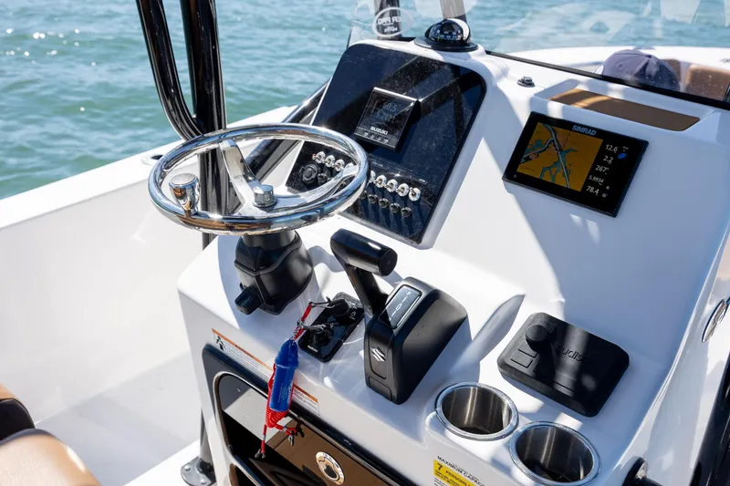 Slide: The Image of 2025 Sea Pro 202 Center Console boat dashboard with steering wheel and navigation display. - 16