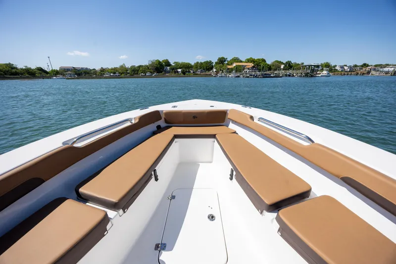 Slide: The Image of 2025 Sea Pro 202 Center Console boat with tan seating, cruising on a calm lake. - 20