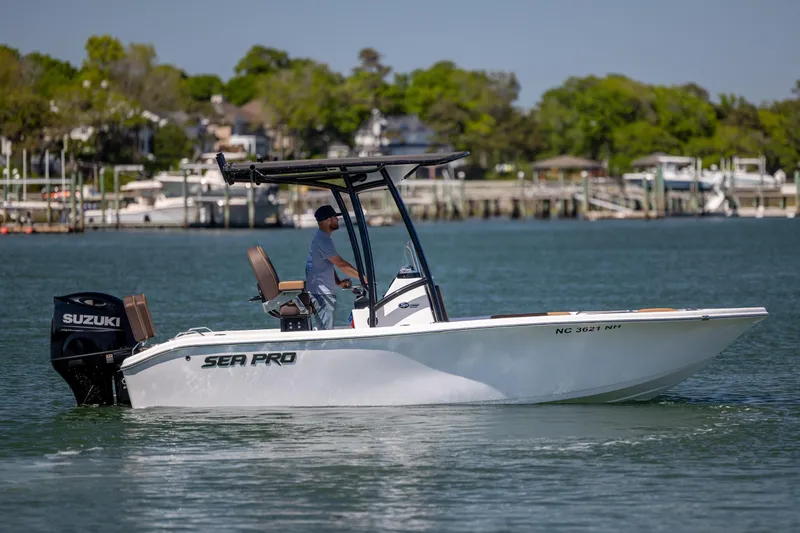 Slide: The Image of 2025 Sea Pro 202 Center Console boat cruising on a calm lake with a Suzuki outboard motor. - 3