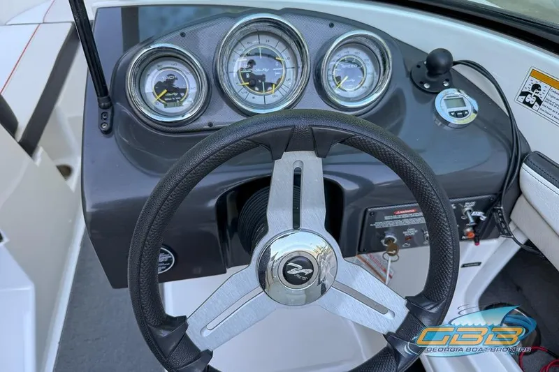 Slide: The Image of Steering wheel and dashboard of 2014 Sea Ray 190 Sport boat, featuring gauges and controls. - 5