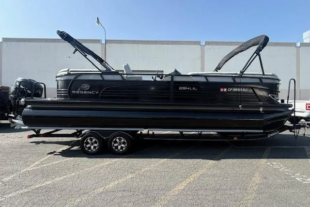 The Image of 2018 Regency 254 LE3 pontoon boat on trailer in parking lot. - 0