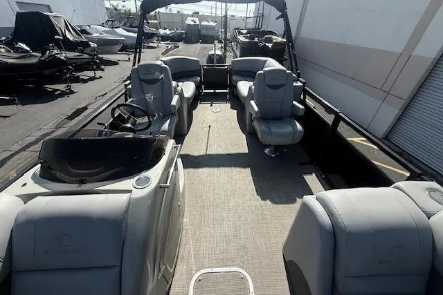 Slide: The Image of 2018 Regency 254 LE3 pontoon boat interior with plush seating and steering console. - 15