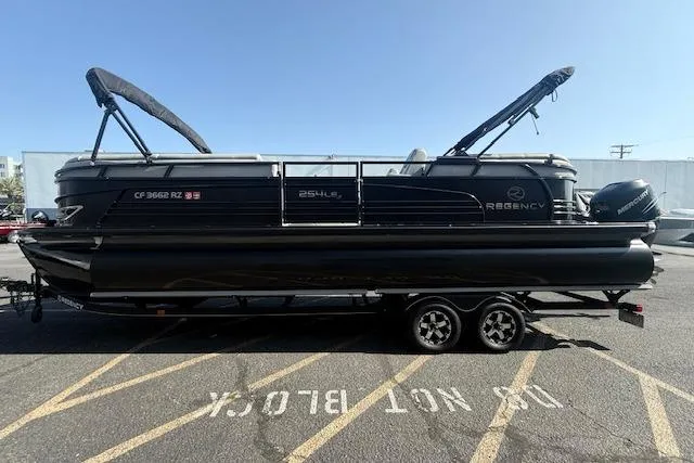 Slide: The Image of 2018 Regency 254 LE3 pontoon boat on trailer in parking lot. - 4