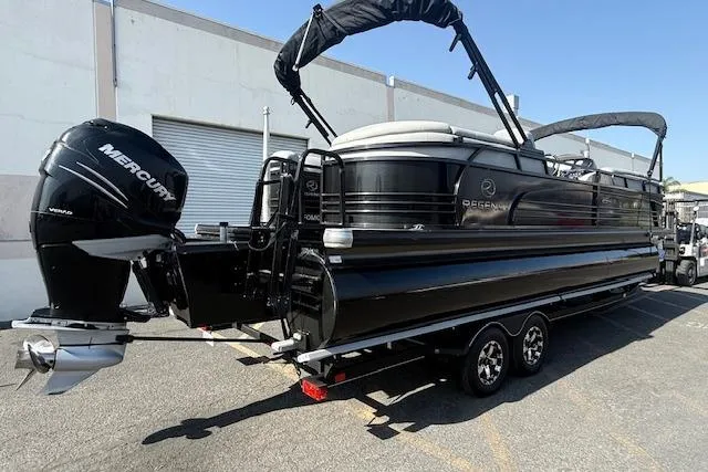 Slide: The Image of 2018 Regency 254 LE3 pontoon boat with Mercury outboard motor, parked on a trailer. - 6