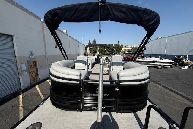 Slide: The Image of 2018 Regency 254 LE3 pontoon boat with canopy in parking lot. - 8