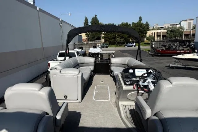 Slide: The Image of 2018 Regency 254 LE3 pontoon boat with spacious seating and canopy in a parking lot. - 9