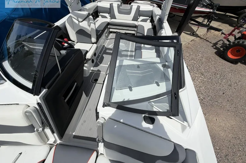 Slide: The Image of 2019 Malibu Wakesetter 24 MXZ boat interior with sleek seating and open windshield. - 11