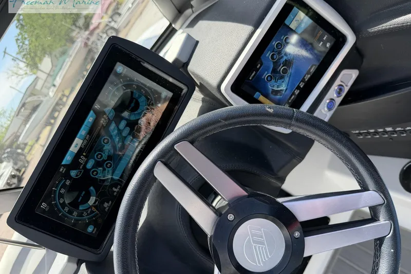 Slide: The Image of Dashboard of a 2019 Malibu Wakesetter 24 MXZ with digital displays and steering wheel. - 26