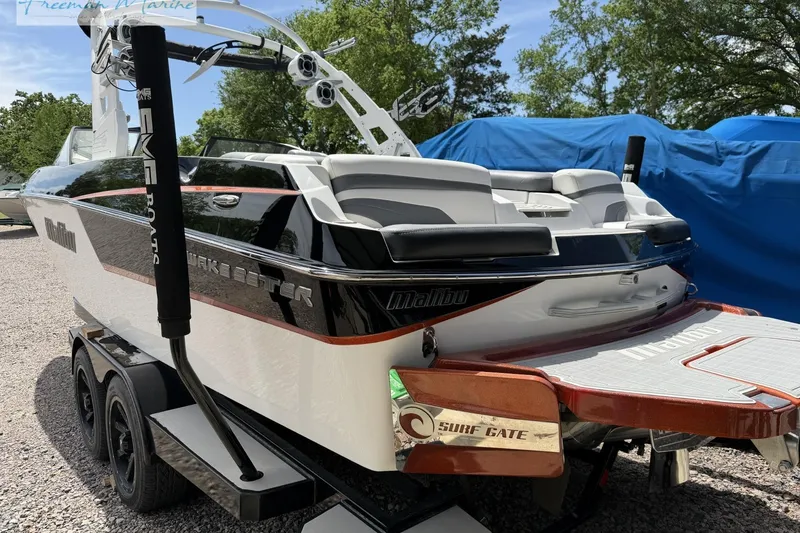 Slide: The Image of 2019 Malibu Wakesetter 24 MXZ boat on trailer, featuring sleek design and surf gate technology. - 4