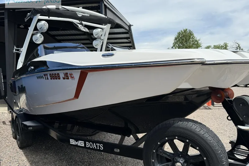 Slide: The Image of 2019 Malibu Wakesetter 24 MXZ boat on trailer, parked outdoors. - 6