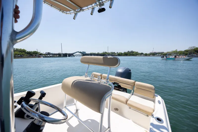 Slide: The Image of 2019 Pioneer 180 Islander boat on calm water, featuring a steering wheel and seating. - 13