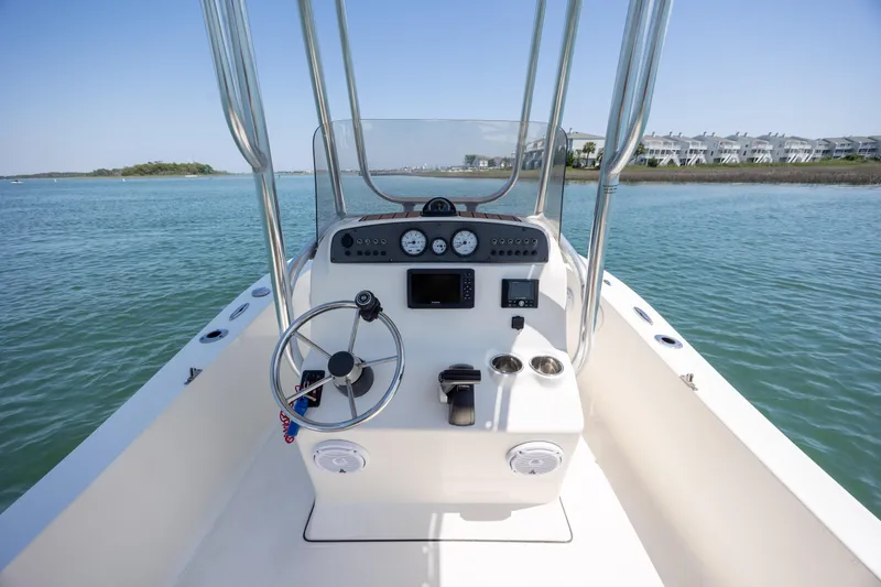 Slide: The Image of 2019 Pioneer 180 Islander boat dashboard on calm water, clear sky, coastal view. - 15