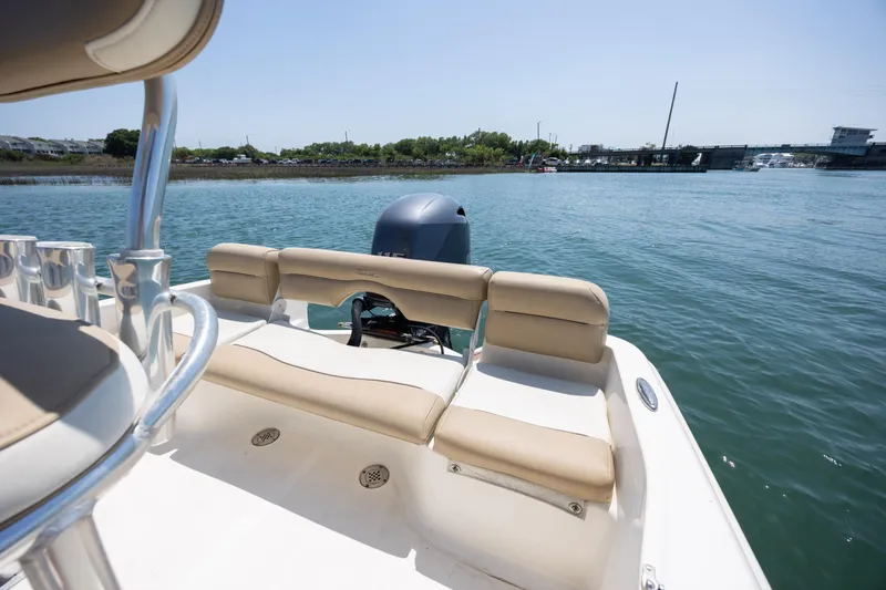 Slide: The Image of 2019 Pioneer 180 Islander boat with beige seating, on calm water near a bridge. - 19