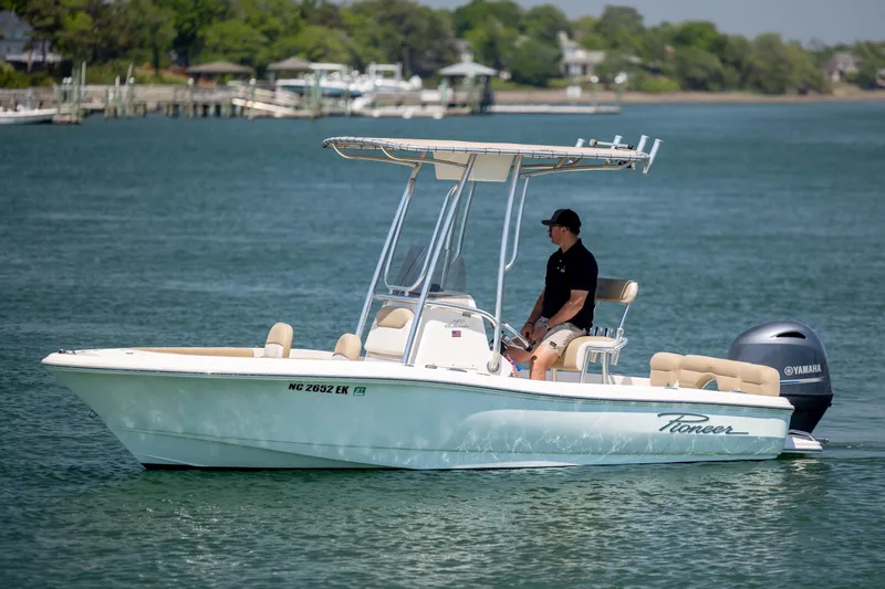 Slide: The Image of 2019 Pioneer 180 Islander boat cruising on a calm lake with a Yamaha engine. - 2