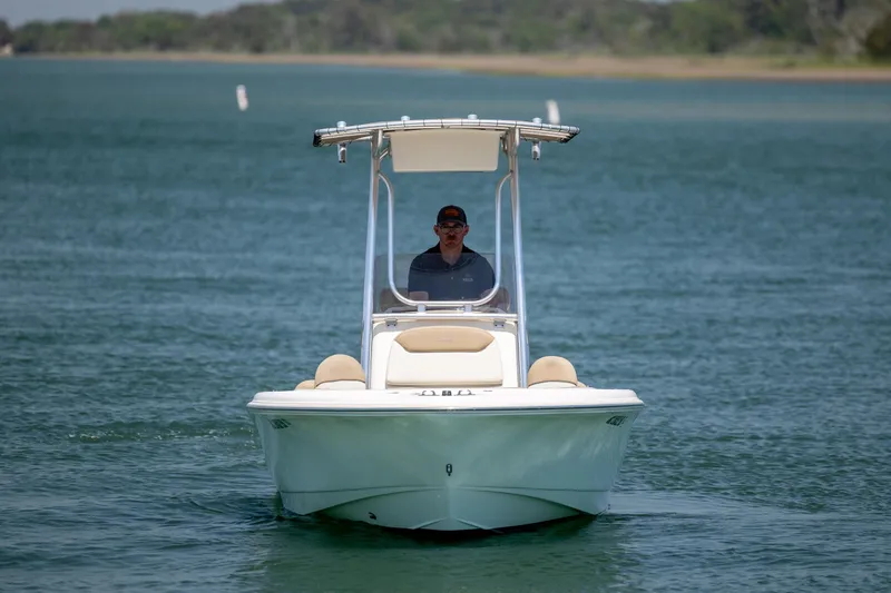 Slide: The Image of 2019 Pioneer 180 Islander boat cruising on a calm lake with a person at the helm. - 3