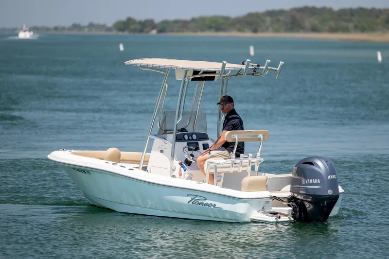 Slide: The Image of 2019 Pioneer 180 Islander boat cruising on a calm lake with a Yamaha outboard motor. - 8