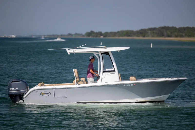 The Image of 2018 Sea Hunt Ultra 235 SE boat cruising on calm waters with Yamaha engine. - 1