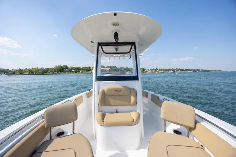 Slide: The Image of 2018 Sea Hunt Ultra 235 SE boat interior with tan seating on a sunny day. - 10
