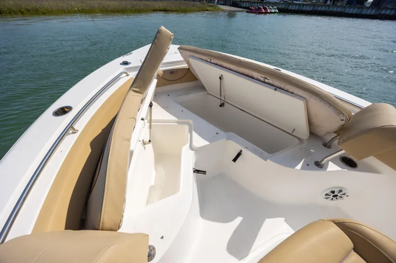 Slide: The Image of 2018 Sea Hunt Ultra 235 SE boat interior with tan seating and storage compartments. - 11