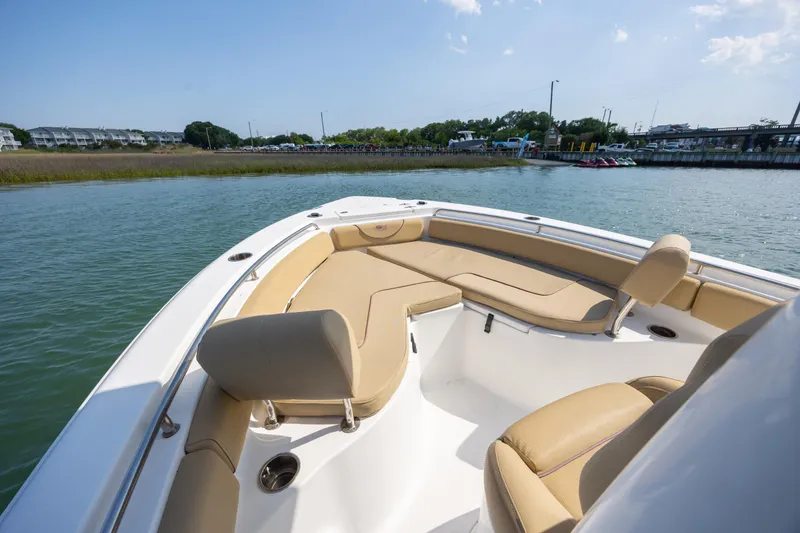 Slide: The Image of 2018 Sea Hunt Ultra 235 SE boat with tan seating, docked in calm waters. - 13
