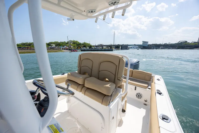 Slide: The Image of 2018 Sea Hunt Ultra 235 SE boat interior with helm and seating on the water. - 15