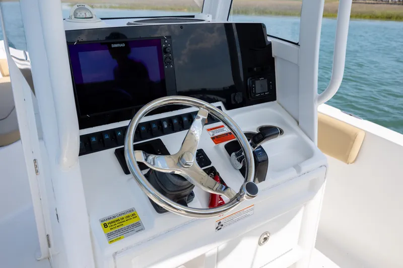 Slide: The Image of 2018 Sea Hunt Ultra 235 SE boat dashboard with steering wheel and navigation controls. - 16
