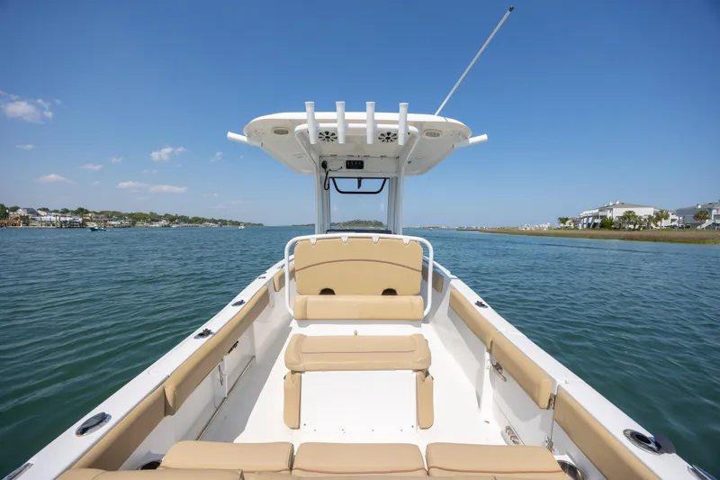 Slide: The Image of 2018 Sea Hunt Ultra 235 SE boat on calm water, clear sky, coastal view. - 21