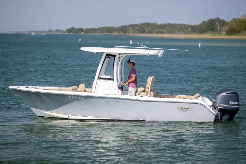 Slide: The Image of 2018 Sea Hunt Ultra 235 SE boat on calm water with Yamaha outboard motor. - 6