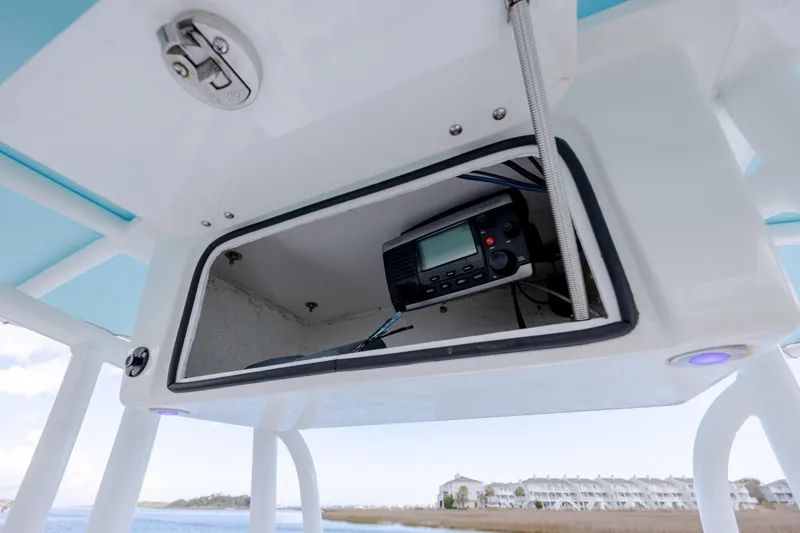 Slide: The Image of Storage compartment with radio equipment on a 2017 Chaos 21 Tarpon Bay boat. - 11