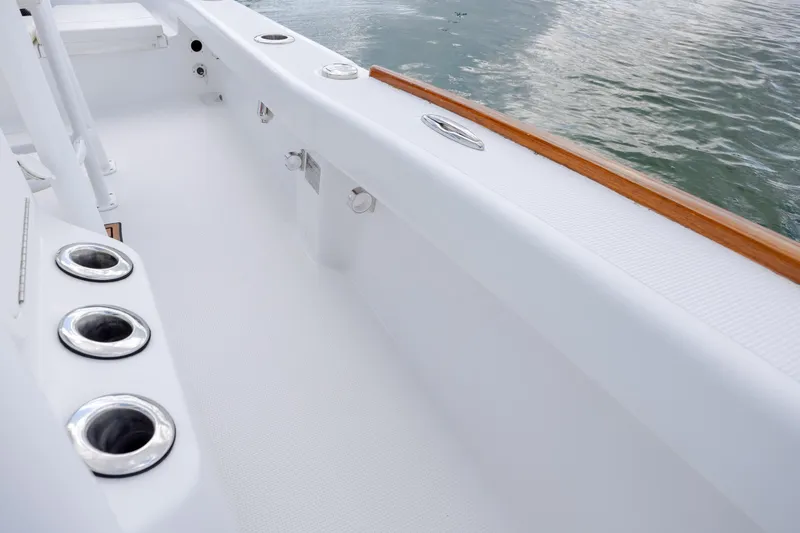 Slide: The Image of 2017 Chaos 21 Tarpon Bay boat interior with rod holders and sleek white finish. - 12