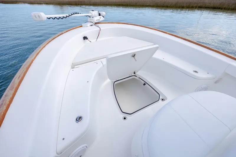 Slide: The Image of 2017 Chaos 21 Tarpon Bay boat interior with open storage compartment on calm water. - 15