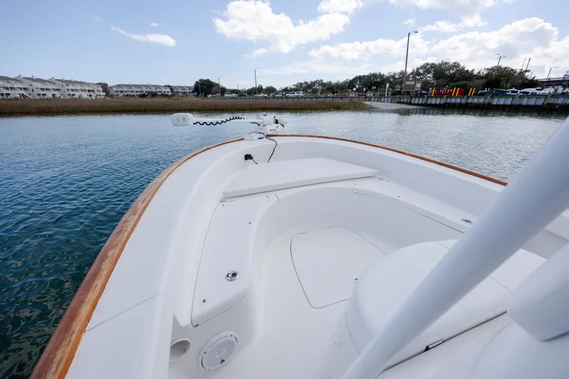 Slide: The Image of 2017 Chaos 21 Tarpon Bay boat on calm water, showcasing sleek design and spacious deck. - 17