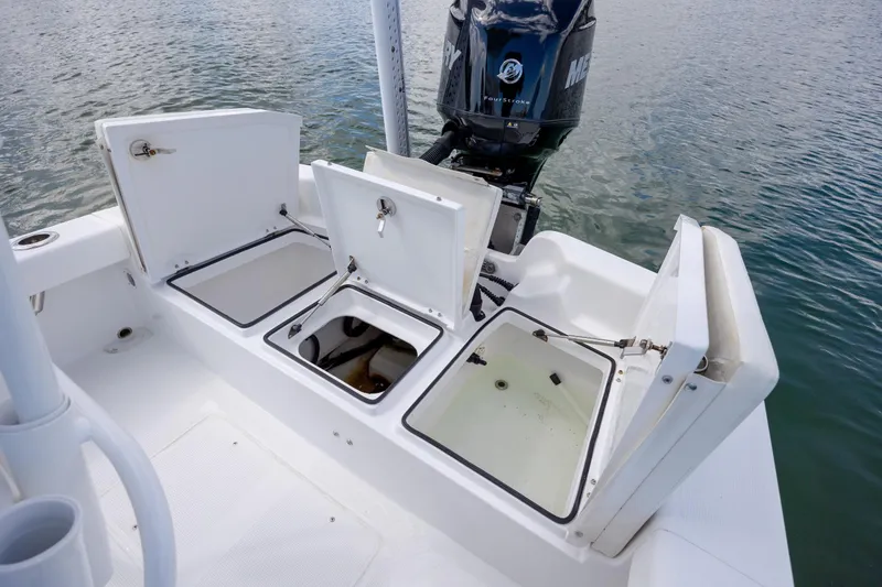 Slide: The Image of 2017 Chaos 21 Tarpon Bay boat with open storage compartments and Mercury engine. - 25
