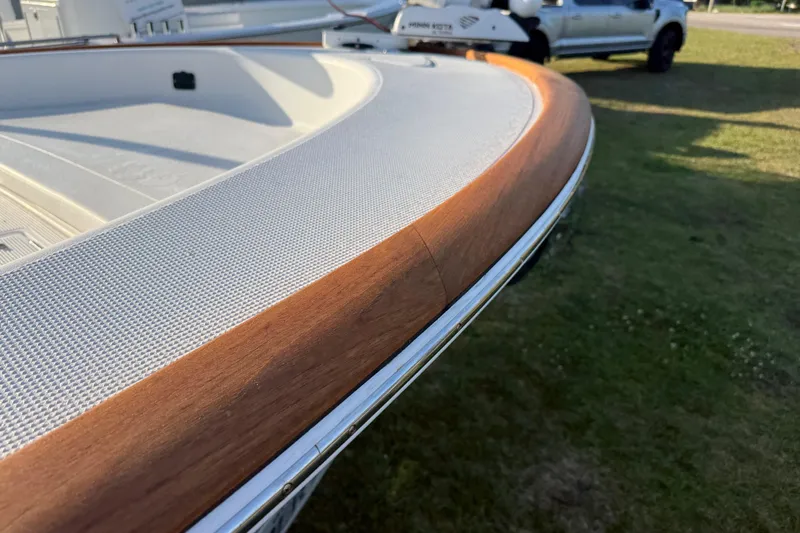 Slide: The Image of 2017 Chaos 21 Tarpon Bay boat with wooden trim detail, parked on grass. - 29