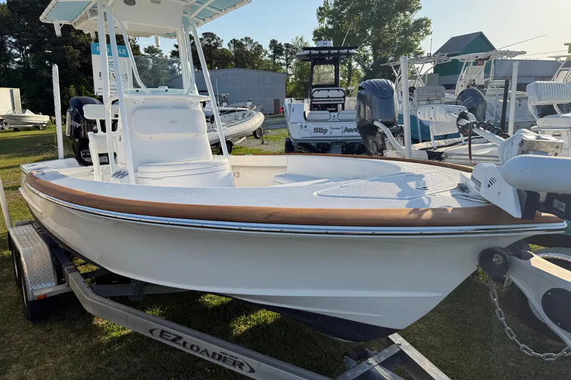 Slide: The Image of 2017 Chaos 21 Tarpon Bay boat on trailer, displayed outdoors with other boats. - 30
