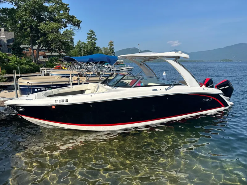 The Image of 2021 Cobalt 30SC boat docked by the lakeside under clear skies. - 0
