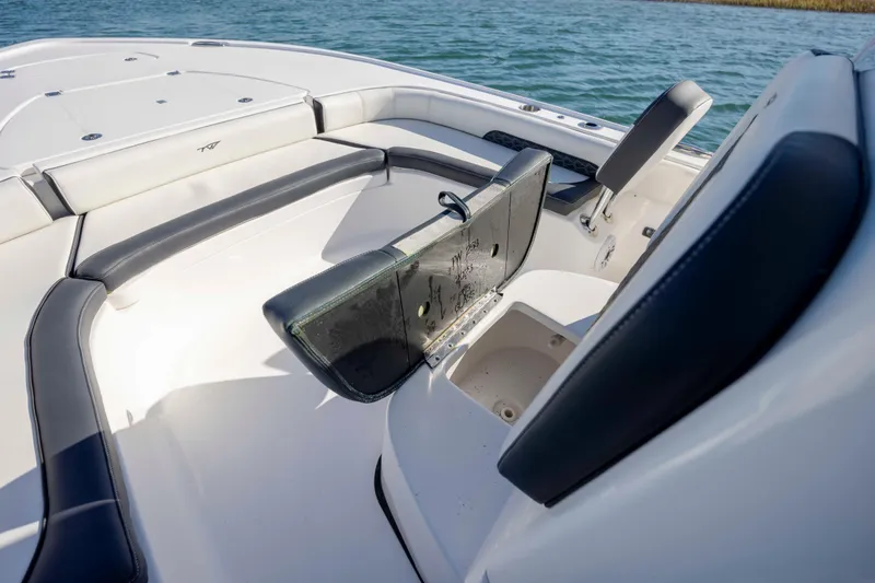 Slide: The Image of 2024 Tidewater 2500 Carolina Bay boat interior with cushioned seating and storage compartments. - 10