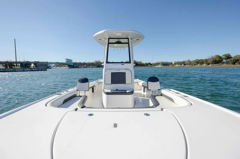Slide: The Image of 2024 Tidewater 2500 Carolina Bay boat on calm water, showcasing sleek design and spacious deck. - 12