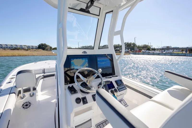 Slide: The Image of 2024 Tidewater 2500 Carolina Bay boat interior with modern navigation system on a sunny day. - 17