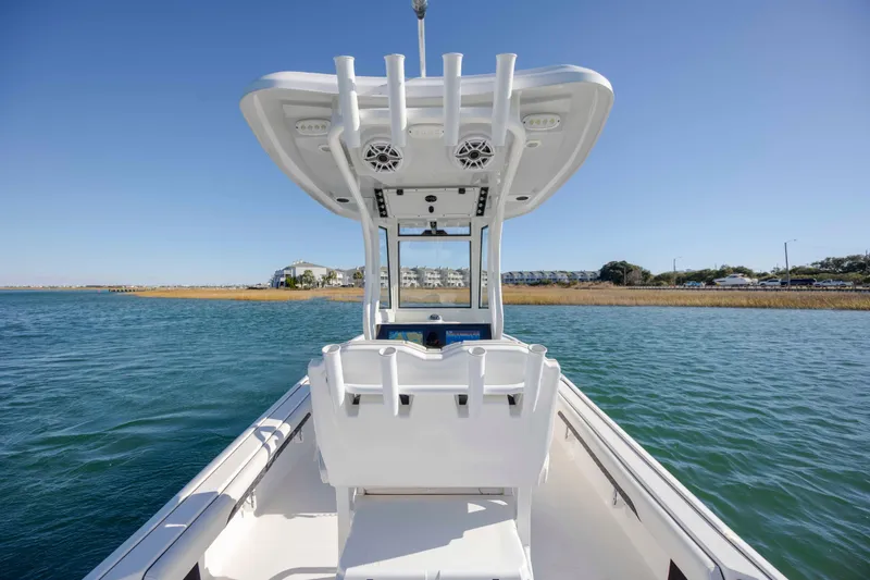 Slide: The Image of 2024 Tidewater 2500 Carolina Bay boat on calm water, showcasing sleek design and spacious deck. - 18