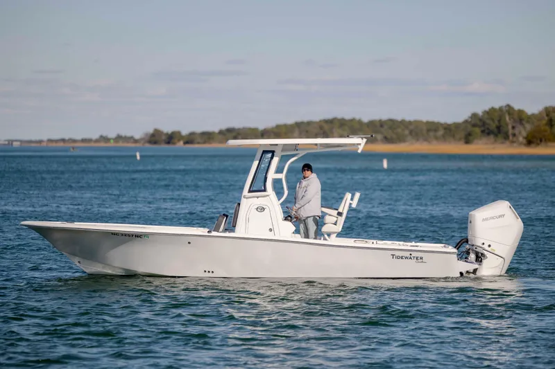 Slide: The Image of 2024 Tidewater 2500 Carolina Bay boat on calm water, featuring sleek design and powerful Mercury engine. - 2