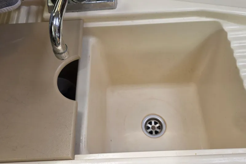 Slide: The Image of Cream-colored sink with faucet and drain, partially covered, in a 1995 Hunter 336. - 12