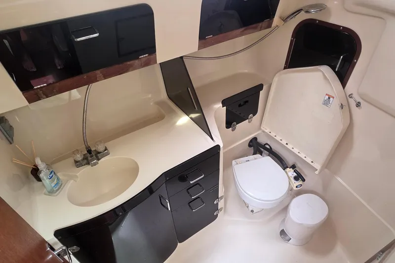 Slide: The Image of Compact bathroom in a 1995 Hunter 336 sailboat, featuring a sink and marine toilet. - 15