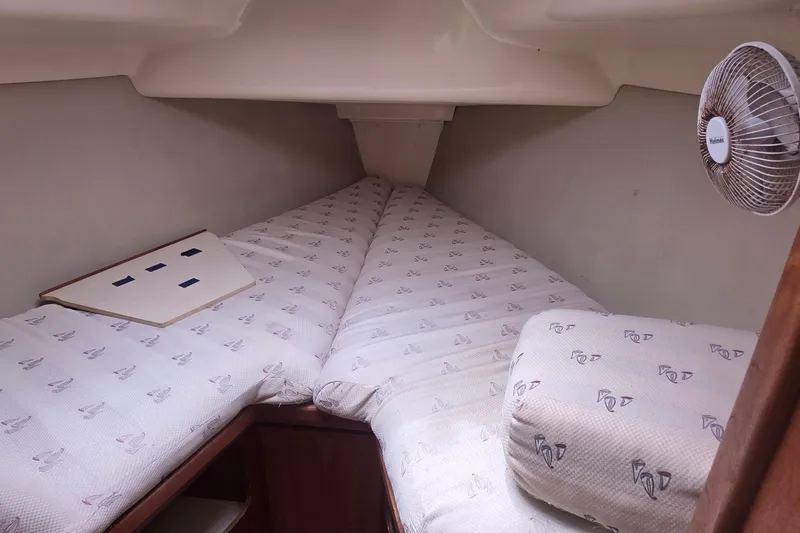 Slide: The Image of Cozy cabin interior of 1995 Hunter 336 sailboat with patterned bedding and fan. - 17