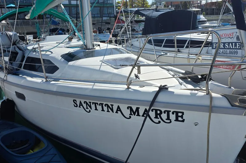 Slide: The Image of Sailboat "Santina Marte" docked, Hunter 336 model, 1995, with a "For Sale" sign visible. - 2