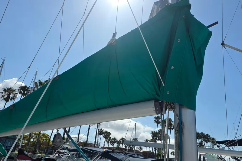 Slide: The Image of Sailboat mast with green sail cover, Hunter 336, 1995 model, under clear blue sky. - 30